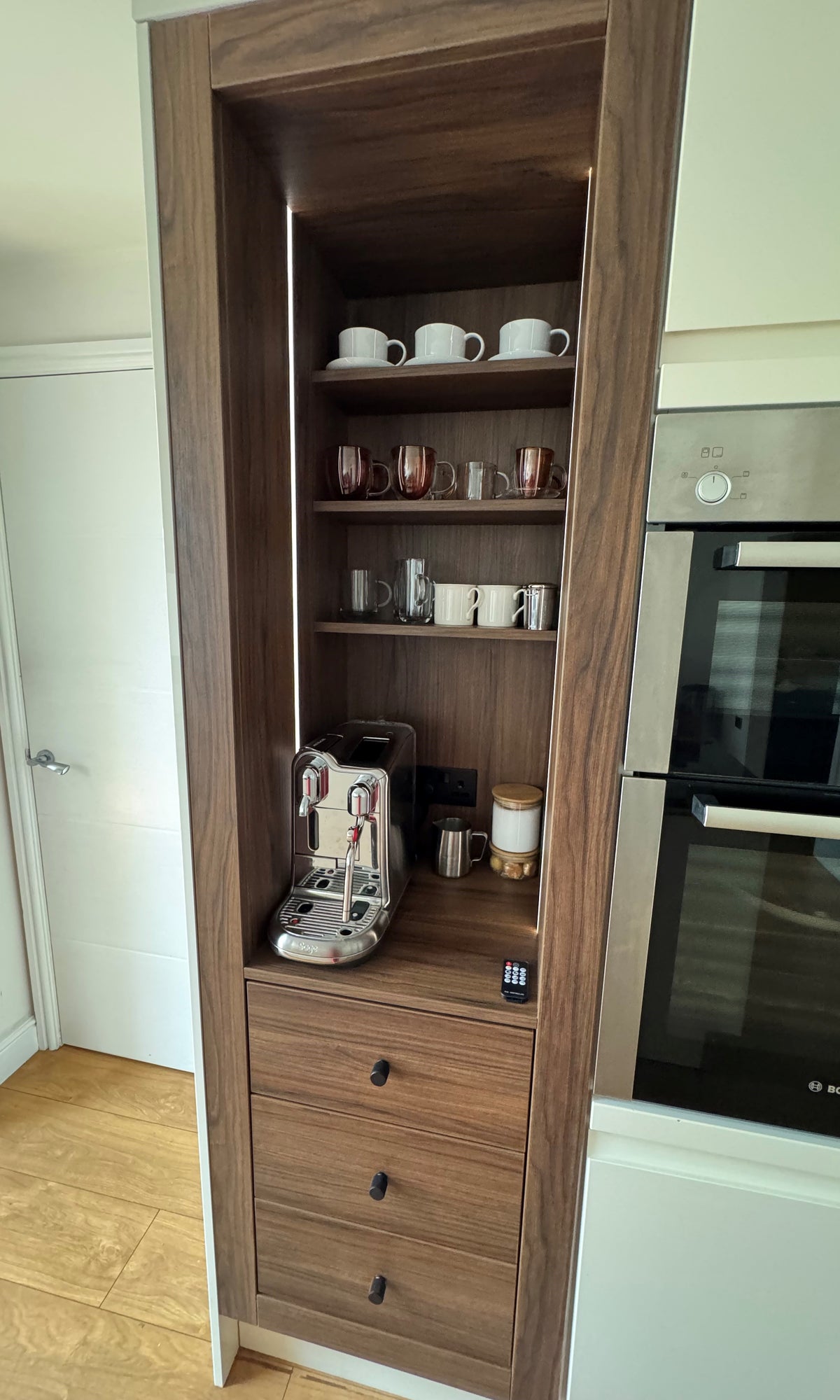 Close up of Portofino Coffee Bar in Walnut Showcasing the Nespresso Creative Pro, Soft Close Drawers, Shevles and LED Lighting