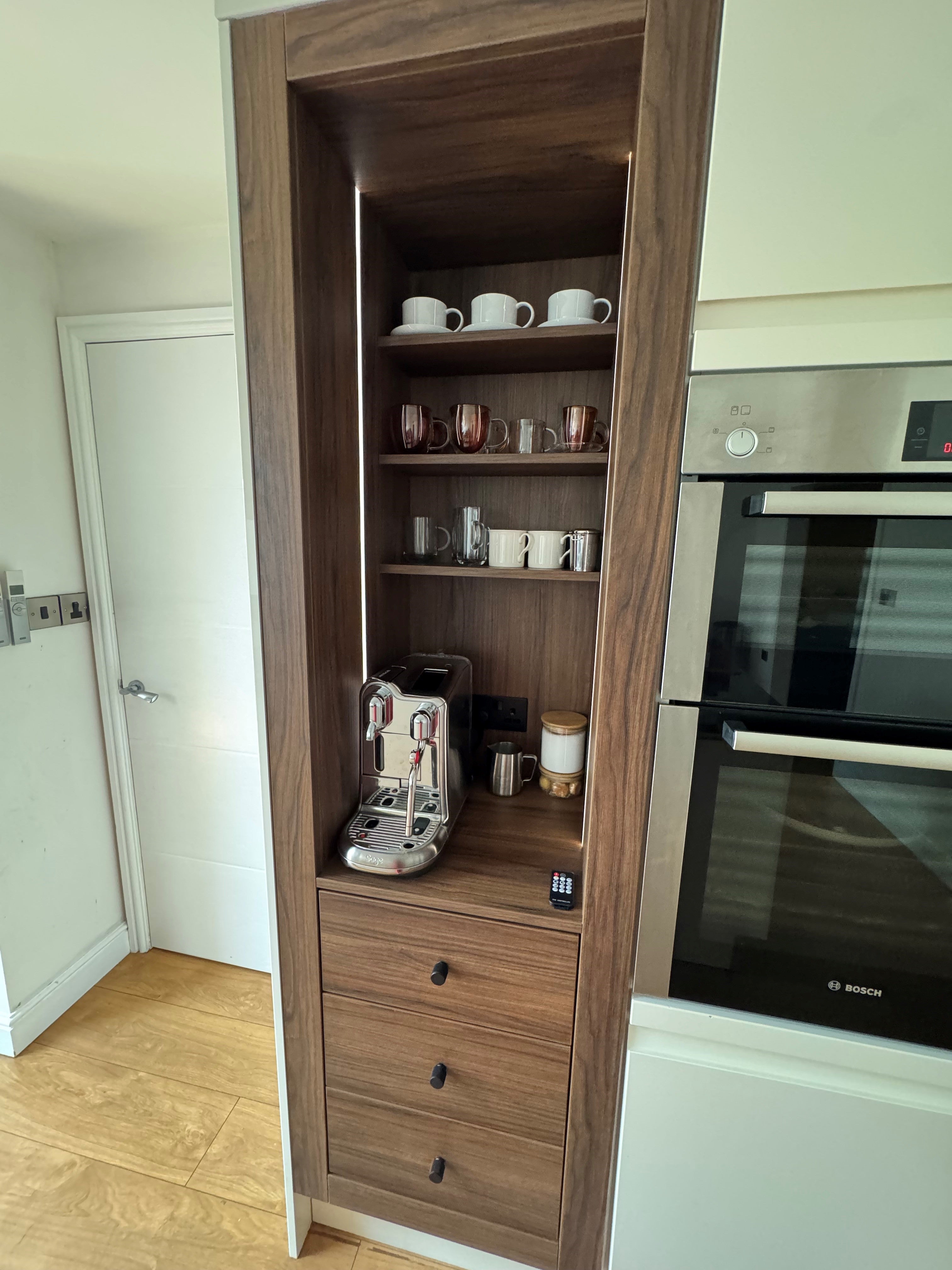 Close up of Portofino Coffee Bar in Walnut Showcasing the Nespresso Creative Pro, Soft Close Drawers, Shevles and LED Lighting